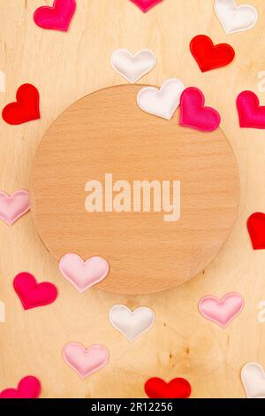 Viele kleine Herzen auf Holzhintergrund mit Kopierraum. Grußkarte mit herzlichen Emotionen auf Naturholz. Stockfoto