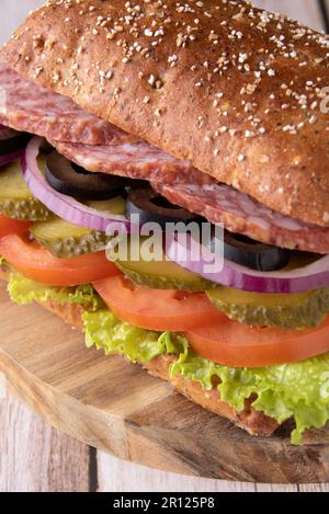 Foto-Sandwich mit Wurst auf einem runden Holzbrett Stockfoto