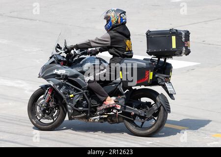 SAMUT PRAKAN, THAILAND, FEBRUAR 07 2023, Fährt Ein Motorradfahrer mit Aufbewahrungsboxen Stockfoto