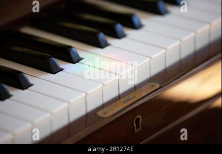 Berlin, Deutschland. 30. April 2023. Auf den Tasten eines Pianos im Wohnzimmer ist eine Lichtreflexion in Regenbogenfarben zu sehen. Kredit: Viola Lopes/dpa/Alamy Live News Stockfoto