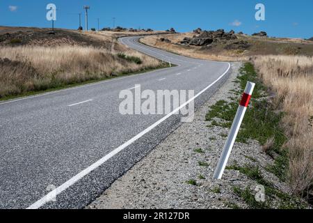 Biegen Sie auf der Straße in der Nähe von Ophir, Ida Valley, Central Otago, South Island, Neuseeland Stockfoto