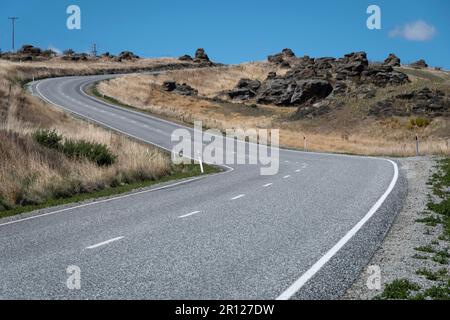 Biegen Sie auf der Straße in der Nähe von Ophir, Ida Valley, Central Otago, South Island, Neuseeland Stockfoto