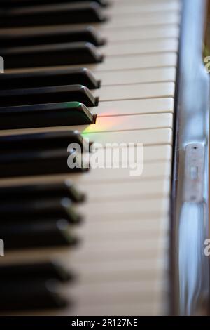 Berlin, Deutschland. 30. April 2023. Auf den Tasten eines Pianos im Wohnzimmer ist eine Lichtreflexion in Regenbogenfarben zu sehen. Kredit: Viola Lopes/dpa/Alamy Live News Stockfoto