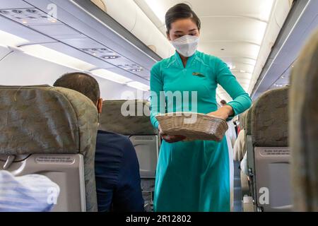 Vietnam Airlines Kabinenbesatzung trägt traditionelle AO dai Uniform auf dem Flug Stockfoto