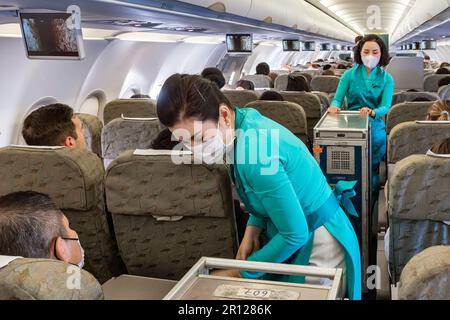 Vietnam Airlines Kabinenbesatzung trägt traditionelle AO dai Uniform auf dem Flug Stockfoto