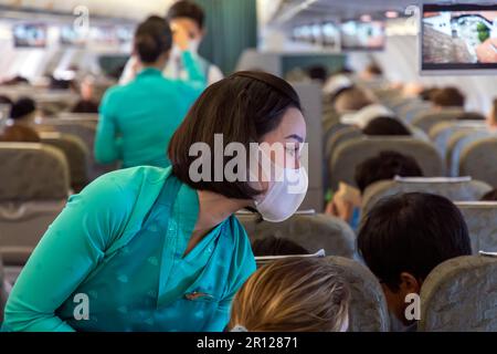 Vietnam Airlines Kabinenbesatzung trägt traditionelle AO dai Uniform auf dem Flug Stockfoto