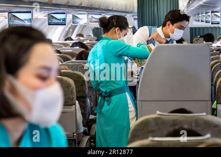 Vietnam Airlines Kabinenbesatzung trägt traditionelle AO dai Uniform auf dem Flug Stockfoto