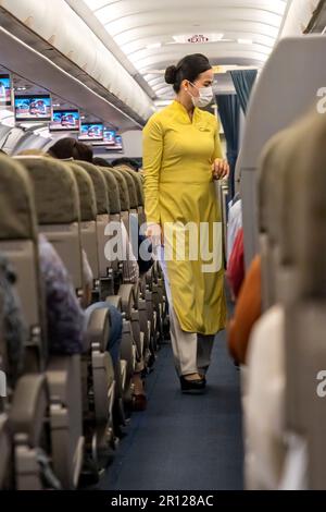 Vietnam Airlines Kabinenbesatzung trägt traditionelle AO dai Uniform auf dem Flug Stockfoto