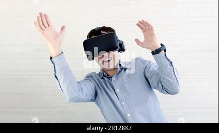 Der glückliche Mann mit VR-Brille schreit. Konzept menschlicher Emotionen, Gesichtsausdruck, moderne Geräte und Technologien. Männlicher in 3D-Headset tanzt auf W. Stockfoto