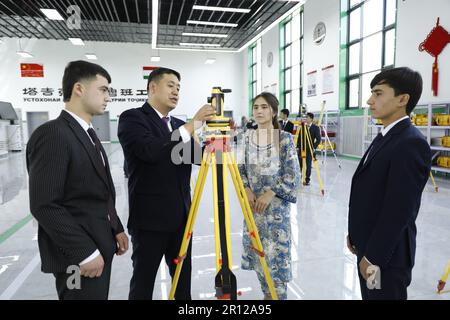 (230511) -- DUSCHANBE, 11. Mai 2023 (Xinhua) -- Wu Zhengpeng (2. L), Lehrer des Tianjin Urban Construction Management & Vocation Technology College, stellt Schülern im Luban Workshop in Duschanbe, Tadschikistan, am 12. April 2023 die Verwendung von Kartierungsgeräten vor. Der Workshop in Luban, der gemeinsam vom chinesischen Urban Construction Management & Vocation Technology College in Tianjin und der Tadschik Technical University gegründet wurde, wurde im November 2022 offiziell in Betrieb genommen. Es erstreckt sich über 1.138 Quadratmeter und ist das erste seiner Art in Zentralasien. Die Werkstatt, benannt nach Lu Ban, einem alten chinesischen Holzwerk Stockfoto