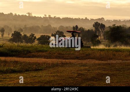 Ein Mann, der einen Rasenmäher fährt, ein Traktor, der auf dem Land arbeitet. Stockfoto