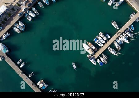 Drohnenlandschaft eines Fischereihafens. Fischerboote und Yachten liegen im Hafen vor. Zygi Marina Zypern Stockfoto