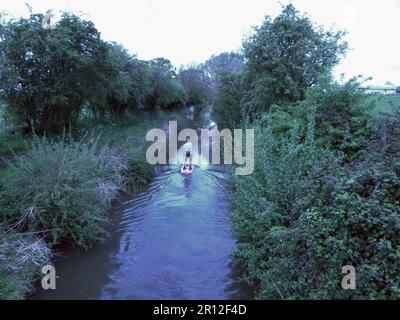 Auf einem Paddelbrett auf einem Kanal nahe Wootton Wawen bei Stratford-upon-Avon Warwickshire balanciert dieser einsame, reife Mann Stockfoto