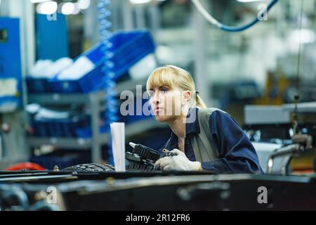 Nizhny Nowgorod, Russland - 21. November 2020: AUTOPRODUKTION IN GAZ. Junge blonde Arbeiterin. Stockfoto