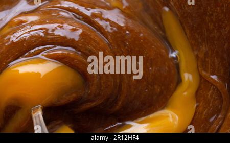 Teig in einer Glasschüssel mischen. Lebensmittelzubereitung, Draufsicht. Stockfoto