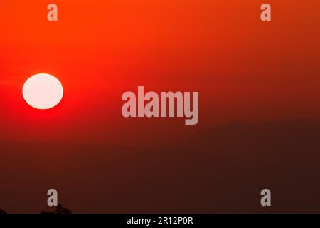 Die Landschaft der aufgehenden Sonne scheint orange am Himmel. Stockfoto