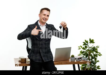 Erfolgreicher weißer, fröhlicher Mann mit einem Schlüssel Stockfoto