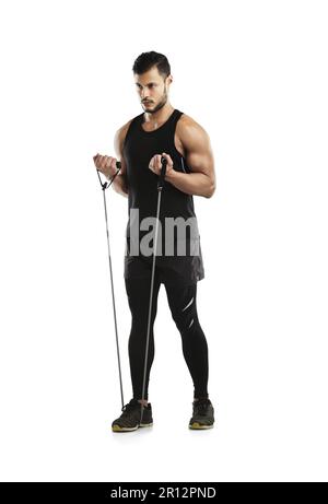 Seine Workouts zu beschleunigen. Studioaufnahme eines jungen Mannes, der mit einem Widerstandsband vor weißem Hintergrund trainiert. Stockfoto