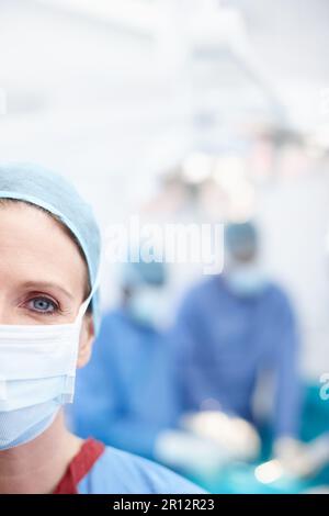 Ich tue alles, was möglich ist. Gekürzte Nahaufnahme einer reifen Chirurgin trägt Krankenhauspeeling und eine schützende Gesichtsmaske - Copyspace. Stockfoto