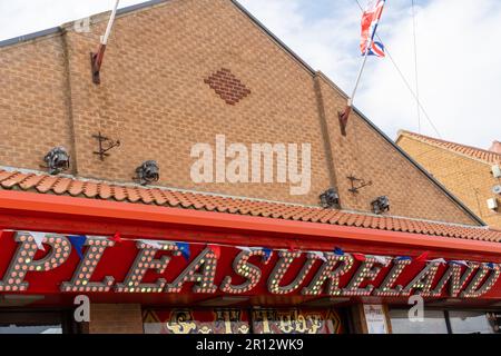 Schild über der Vergnügungs- oder Spielautomatenhalle „Pleasureland“ in der Stadt Whitby, North Yorkshire, Großbritannien. Stockfoto