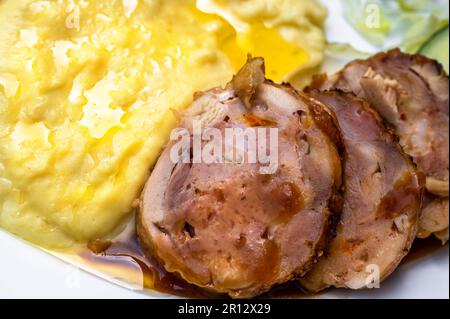 Detail von Kartoffelpüree mit Hähnchenfleisch-Roulade mit Käse und Cranberrys auf weißem Teller. Stockfoto