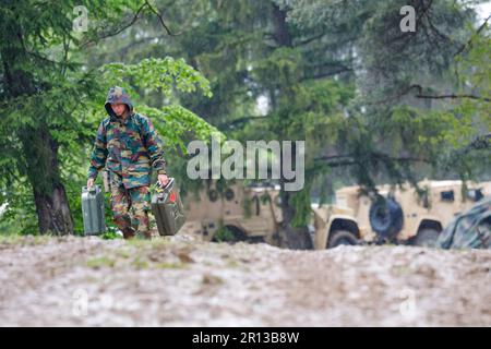 Hohenfels, Deutschland. 11. Mai 2023. Während der USA läuft ein Soldat mit Kanistern durch den Schlamm Der Medientag Der Armee. Kredit: Daniel Löb/dpa/Alamy Live News Stockfoto