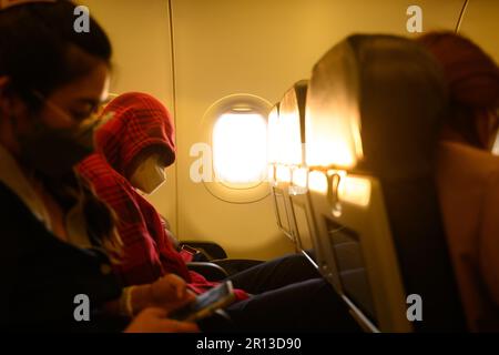 Das Innere eines großen Passagierflugzeugs mit Personen auf Sitzen Stockfoto
