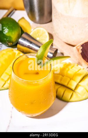 Mango-Kokosnuss-margarita-Cocktail, alkoholfreier Mocktail, indische Mango mit frischen jungen Kokosnüssen und Mangofrüchten, auf farbigem Hintergrund Stockfoto