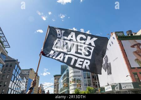 Ein Protestteilnehmer beim Jordan Neely March steht in einer Menge mit einem Schild, auf dem steht "Black Lives Matter". Stockfoto