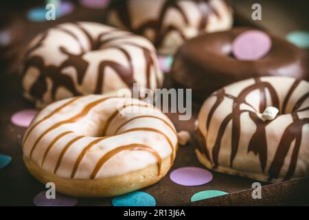 Schokoladen-Donuts, Berliner, Krapfen auf einem rostigen Tablett auf dunklem Hintergrund, Nahaufnahme Stockfoto