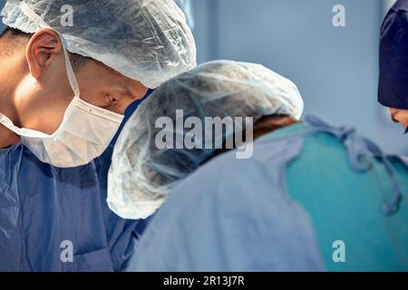 Gesichter von Chirurgen Nahaufnahme während einer komplexen und intensiven Operation retten Ärzte das Leben des Patienten, Teamarbeit von Chirurgen. Stockfoto