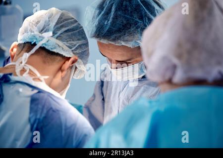 Gesichter von Chirurgen Nahaufnahme während einer komplexen und intensiven Operation retten Ärzte das Leben des Patienten, Teamarbeit von Chirurgen. Stockfoto
