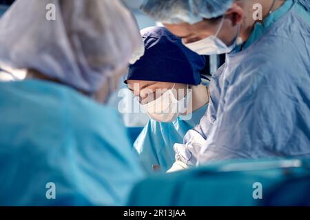 Gesichter von Chirurgen Nahaufnahme während einer komplexen und intensiven Operation retten Ärzte das Leben des Patienten, Teamarbeit von Chirurgen. Stockfoto