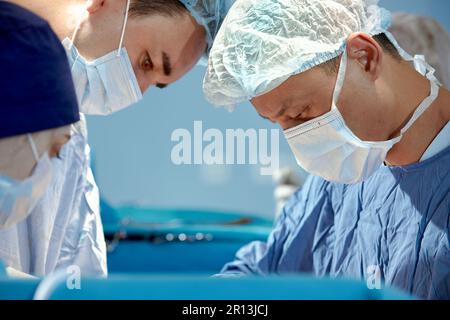Gesichter von Chirurgen Nahaufnahme während einer komplexen und intensiven Operation retten Ärzte das Leben des Patienten, Teamarbeit von Chirurgen. Stockfoto