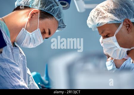 Gesichter von Chirurgen Nahaufnahme während einer komplexen und intensiven Operation retten Ärzte das Leben des Patienten, Teamarbeit von Chirurgen Stockfoto