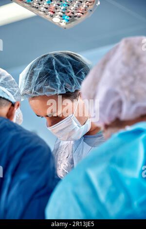 Gesichter von Chirurgen Nahaufnahme während einer komplexen und intensiven Operation retten Ärzte das Leben des Patienten, Teamarbeit von Chirurgen. Stockfoto