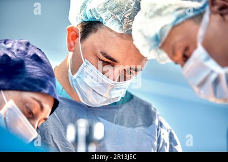 Gesichter von Chirurgen Nahaufnahme während einer komplexen und intensiven Operation retten Ärzte das Leben des Patienten, Teamarbeit von Chirurgen. Stockfoto
