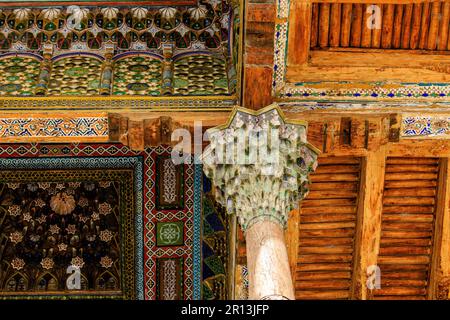 Details des aufwendig geschnitzten farbenfrohen Holzdachs des iwan der Bolo-hauz-Moschee in bukhara usbekistan Stockfoto