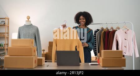 Vlogger, Blogger, kleines KMU-Unternehmen, asiatische Schönheit, die Livestreaming von Mobiltelefonen verwendet, um Kleidung zu verkaufen, Livestream verkauft, online verkauft, Produkt zeigen Stockfoto