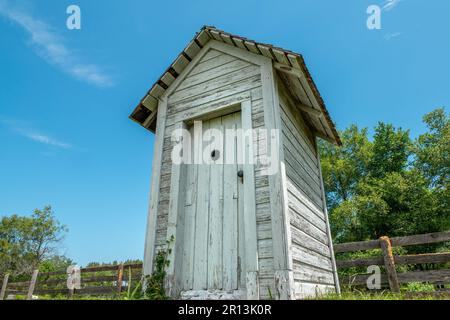 Ein altes verwittertes Klo erinnert an vergangene Zeiten in dieser Landschaft von Wisconsin. Stockfoto