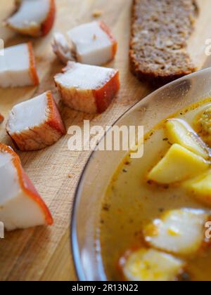 Einfaches Essen. Suppe und Schmalzstücke liegen auf einem Holztisch. Nahaufnahme. Blick von oben Stockfoto