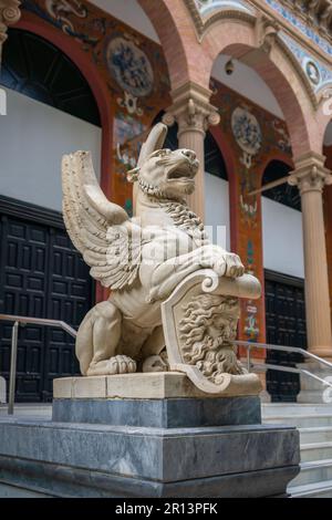 Geflügelte Löwenskulptur vor dem Velazquez Palast (Palacio de Velazquez) im Retiro Park - Madrid, Spanien Stockfoto