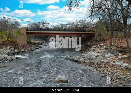 Eine rote Brücke, die einen schnellen Fluss überquert Stockfoto