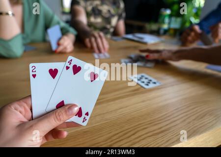 Eine Frau, die mit Freunden Karten spielt. Stockfoto