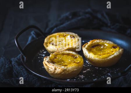 Traditionelles portugiesisches Dessert, Pastell de Nata, Pasteis de Nata, Eierkarte, auf schwarzem Hintergrund Stockfoto