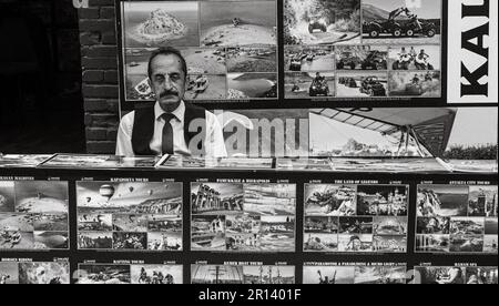 Ein düsterer Türke sitzt hinter einem Touristenschalter in den Straßen der Altstadt von Kaleici in Antalya, Türkei (Turkiye). Sein dicker schwarzer Schnurrbart und Stockfoto