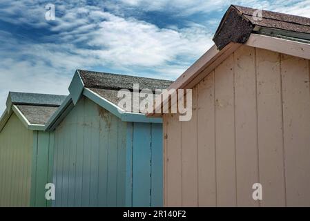 Die Rückseite von drei Strandhütten in Pastelltönen in Buddleigh Salterton, Devon, England Stockfoto