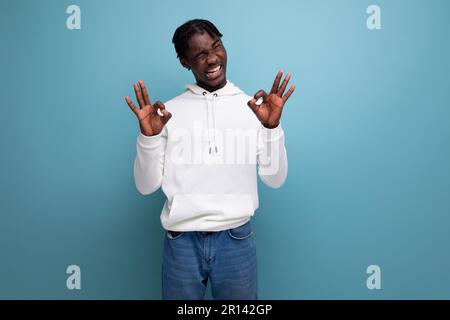 Ein geschickter afrikanischer junger Mann mit Dreadlocks zeigt, dass alles in Ordnung ist Stockfoto