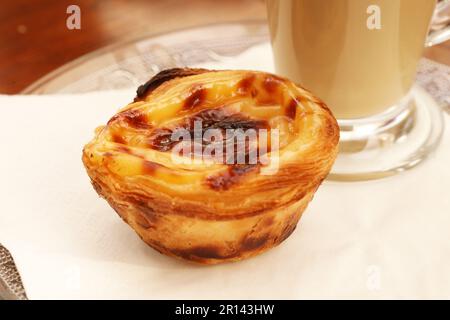 Nahaufnahme eines Pastel de Nata auf einer Glasplatte, portugiesische Custard Torten Stockfoto