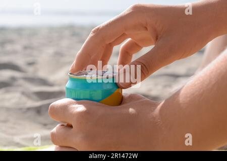 Frau öffnet Aluminiumdose mit Getränk am Strand, Nahaufnahme Stockfoto